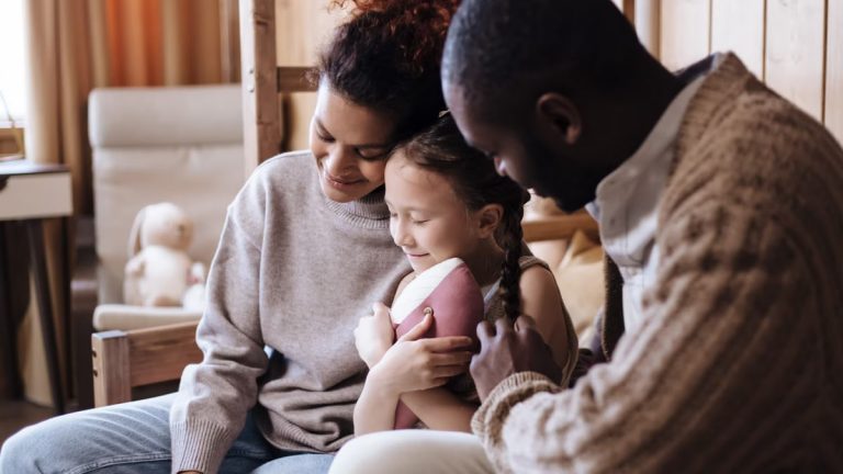 Warm family moment indoors with parents embracing their child, promoting joy and togetherness.
